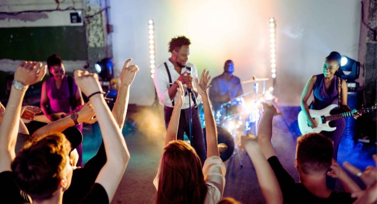 Foule levant les mains devant des musiciens sur scène lors d'un concert à Paris