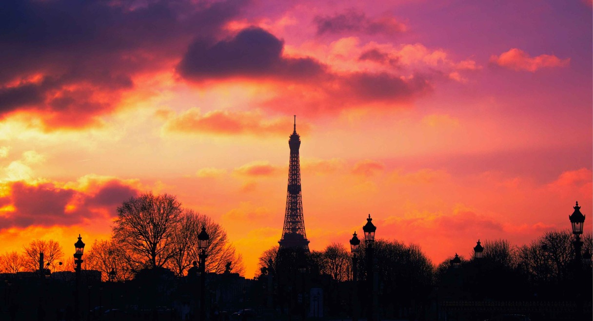 Silhouette de la tour Eiffel sur fond de coucher de soleil orangé à Paris
