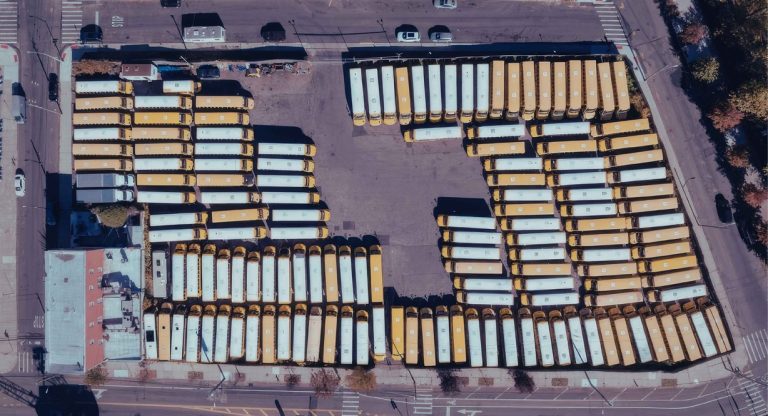 Vue aérienne d'un grand parking avec de nombreuses voitures garées en rangées