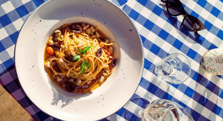 Assiette de pasta italienne sur une nappe à carreaux dans un restaurant