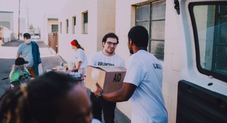 Bénévoles associatifs distribuant des colis d'aide humanitaire dans la rue