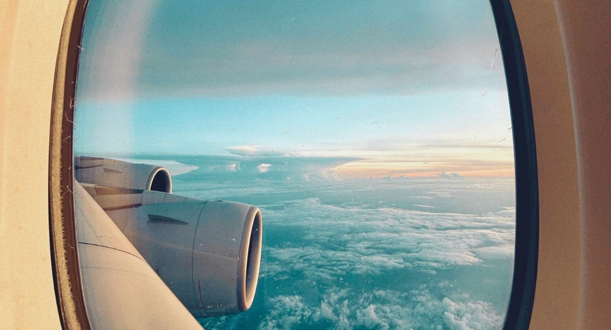 Vue depuis le hublot d'un avion survolant une mer de nuages