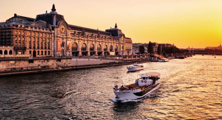 Bateau touristique naviguant sur la Seine au coucher du soleil a Paris