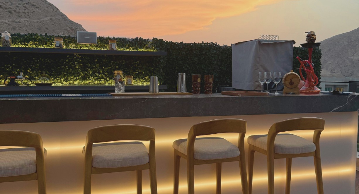 Comptoir de bar rooftop avec vue panoramique au coucher du soleil